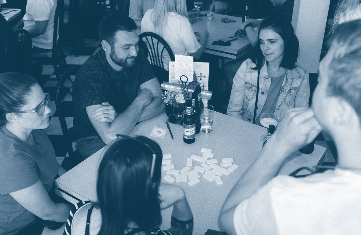 A group of people playing dominoes.